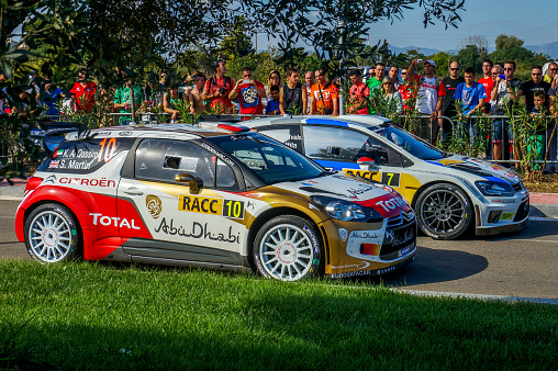 Salou, Spain - October 24, 2013: At the background is a Finnish driver Jari-Matti Latvala and his codriver Mikka Anttila in a Volkswagen Polo R WRC and at the foreground is  the driver Khalid Al Qassimi with his codriver Scott Martin in a Citroën DS3 WRC after the stage 9, race in the 49th RACC Rally of Spain. Latvala Wins the stage.