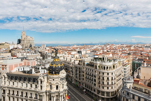 Aerial view of Gran Vía and Madrid's skyline on a Summer early morning, with the Metropolis building to be recognized in the foreground. Some other landmarks like the Telefonica Building to Faro de Moncloa are also to be recognised.