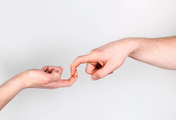 istock Fingers of Two People Nearly Touching 513792394
