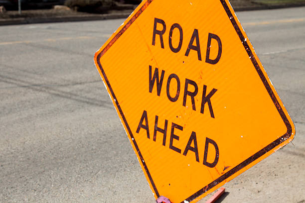 istock Road work ahead sign against asphalt road 513792676