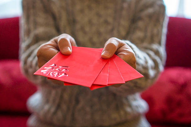 dając czerwona koperta z pieniędzmi na wakacjach - happy new year zdjęcia i obrazy z banku zdjęć