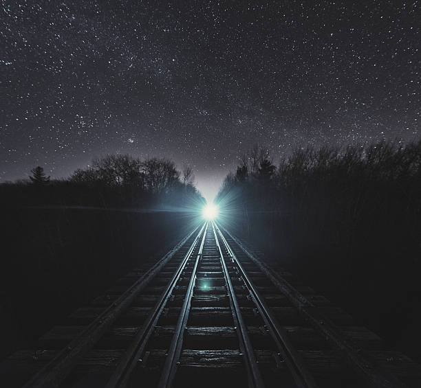 Night Train Standing in the middle of a bridge with a train fast approaching.  Long exposure. freight train stock pictures, royalty-free photos & images