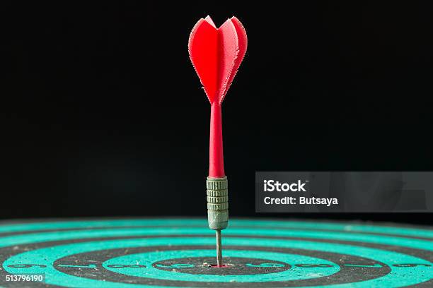 Dart Arrow Hitting In The Center Of Green Dartboard Stock Photo - Download Image Now