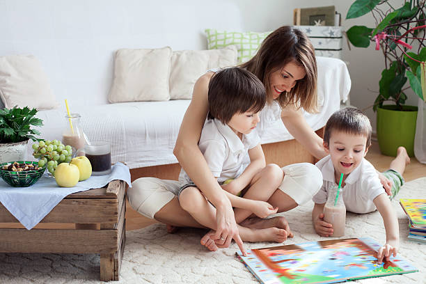 istock Young mother, read a book to her tho children, boys 513796862