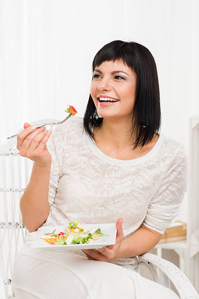 istock Smiling woman eating fresh vegetable salad 513797210