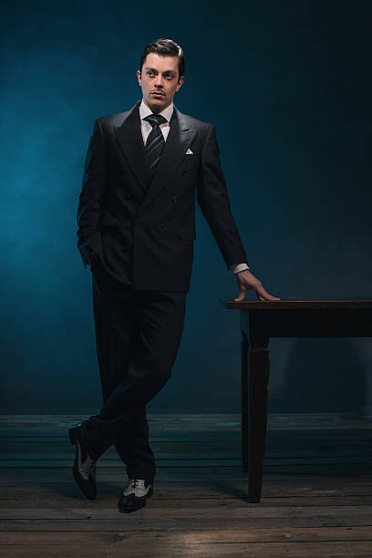 istock Retro 1940s business man in suit standing next to desk. 513798470