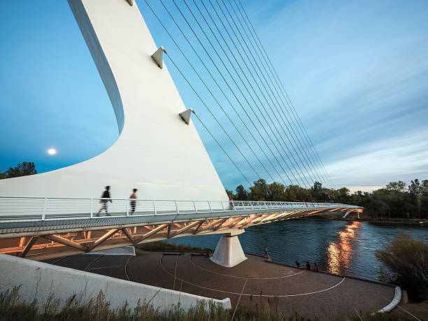 Twilight moon rise over the Sundial Bridge, CA Redding, California, USA - October 25, 2015:  Moon sets over unique cantilever spar cable-stayed bridge which spans the Sacramento River in Northern California. editorial architecture famous place local landmark stock pictures, royalty-free photos & images