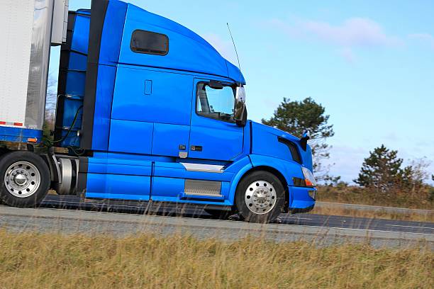 istock Semi truck on a highway trees in background 513801202