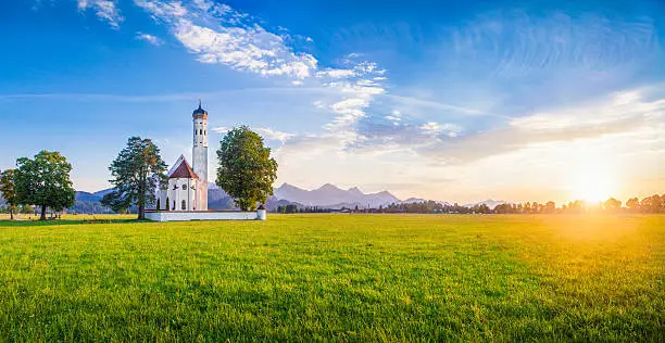 Panoramic view of famous St. Coloman church near Fussen in beautiful evening light at sunset in summer, Schwangau, Bavaria, Germany.