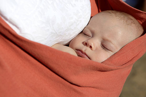 istock Newborn boy sleeping in baby sling carrier 513804134
