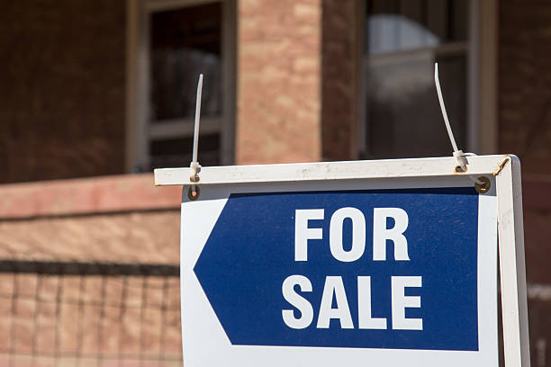 istock Blue for sale sign in front of a brick home 513804312
