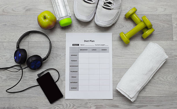 istock Various sport equipment with diet plan on wooden background 513805712