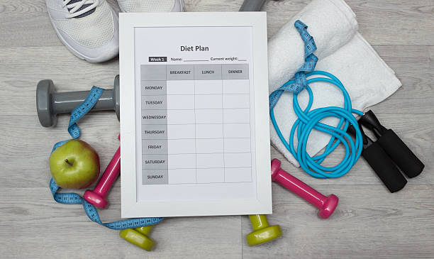 istock Various sport equipment with diet plan on wooden background 513806656