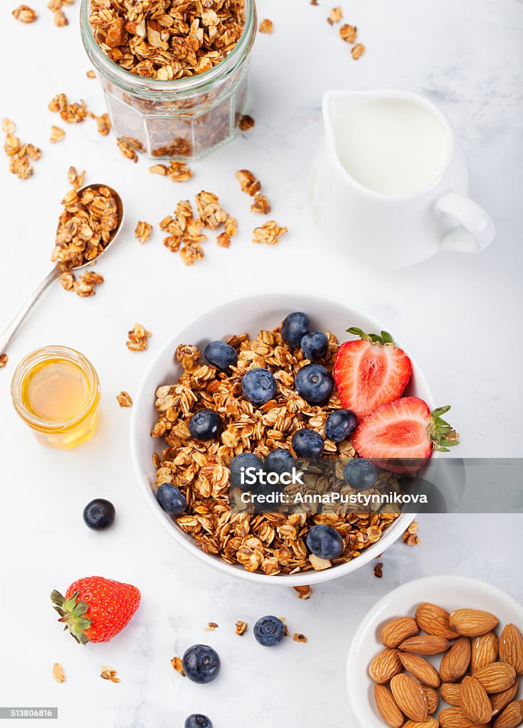 Healthy breakfast Fresh granola, muesli in bowl Healthy breakfast Fresh granola, muesli in bowl with milk and berries on a white background Top view Breakfast Stock Photo