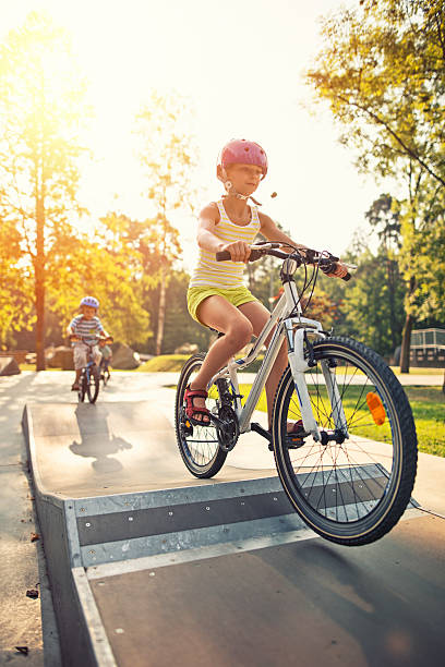 niña pequeña y su firmados montar bicicletas en la rampa. - bmx cycling bicycle cycling sport fotografías e imágenes de stock