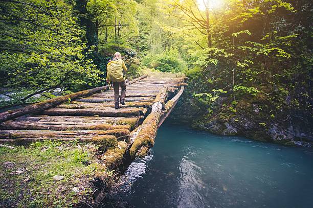 istock Woman Traveler with backpack hiking on bridge 513814970