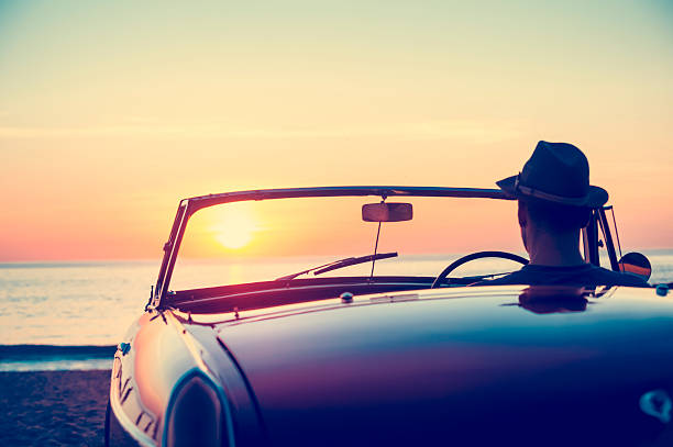 istock Mature man driving a convertible car at the beach. 513819982