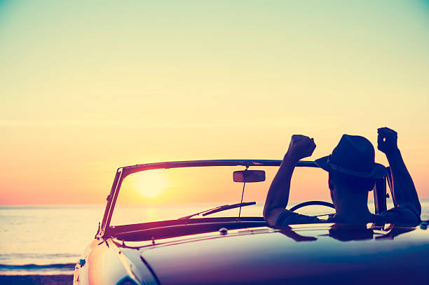 istock Mature man driving a convertible car at the beach. 513820292
