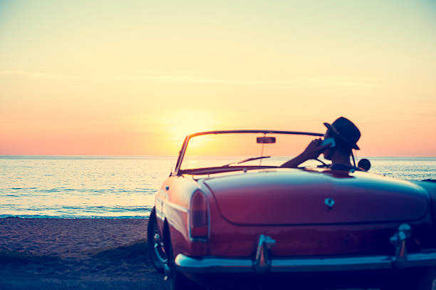 istock Mature man driving a convertible car at the beach. 513820476