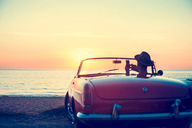istock Mature man driving a convertible car at the beach. 513820532