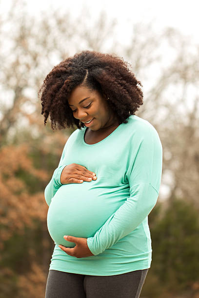 mulher afro-americana grávida - one person women human pregnancy beautiful imagens e fotografias de stock
