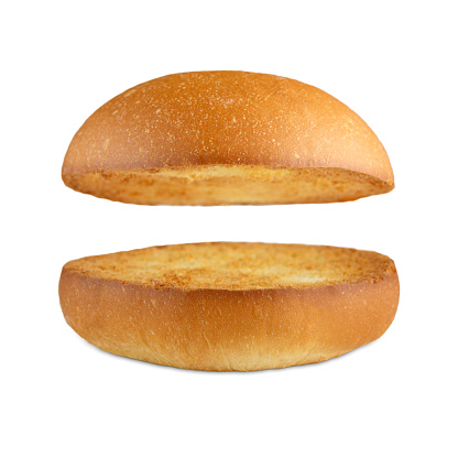Burger bun empty isolated. American food classic burger round bun isolated at white background. Burger bun without fillings. Roasted toasted hamburger bun layers flying, levitating at white. 