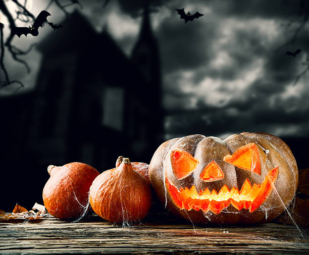 istock Halloween pumpkins on wood with dark background 513824905