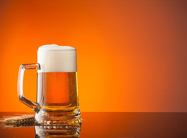 istock Glass of beer with orange background 513825271