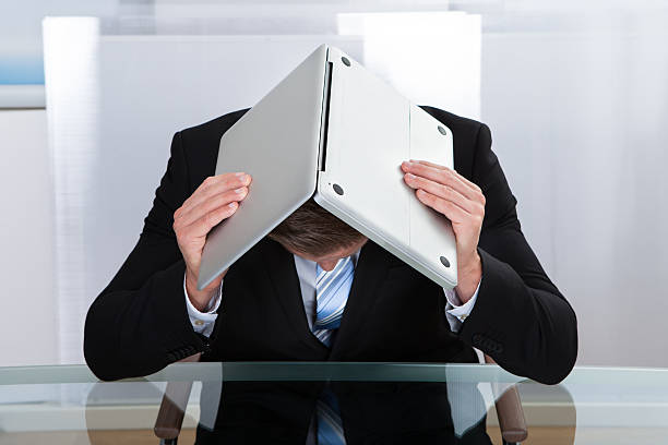 istock Depressed businessman hiding under his laptop 513828691