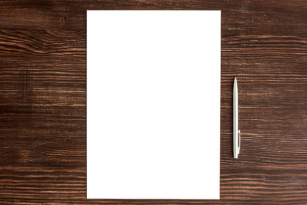 istock Pen and white card on wooden desk 513829027