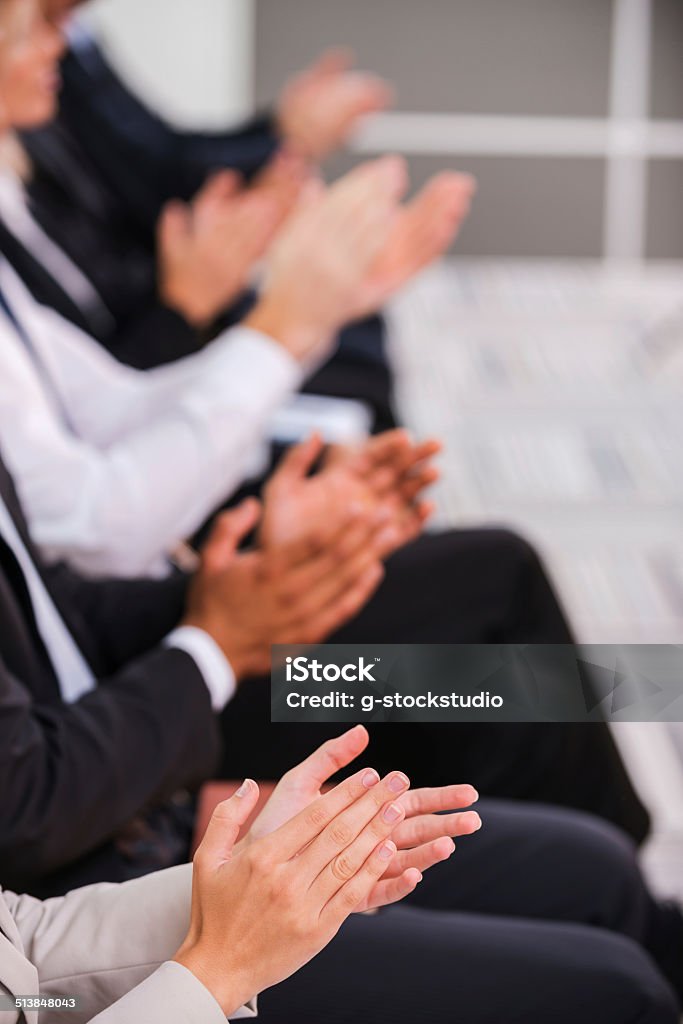 People applauding. Group of business people clapping hand while sitting in a row Applauding Stock Photo