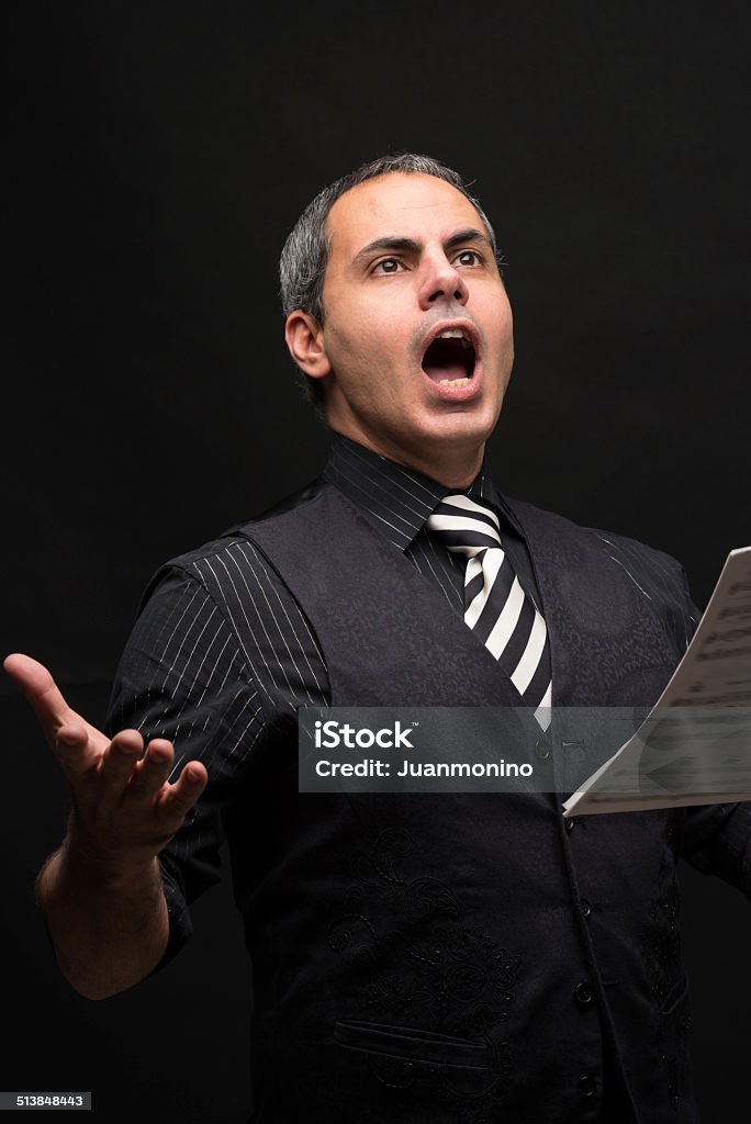 Opera singer mature man singing opera on black background Opera Singer Stock Photo