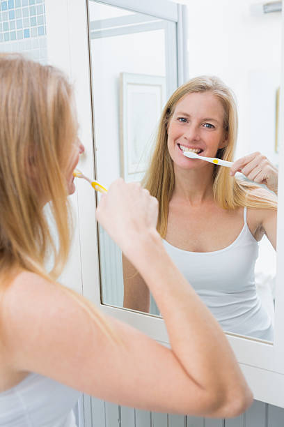 istock Happy woman brushing her teeth 513850733