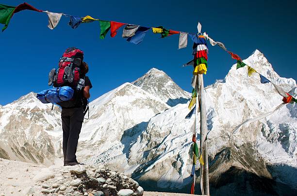 evening view of Everest with tourist evening view of Everest with tourist and buddhist prayer flags from kala patthar and blue sky - way to Everest Base Camp - Nepal base camp photos stock pictures, royalty-free photos & images