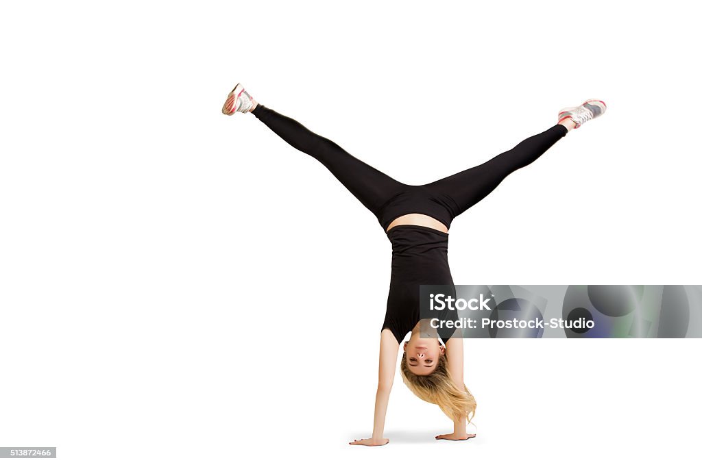 Caucasian woman doing cartwheel isolated on white Caucasian woman does cartwheel gymnastics. Fitness girl in handstand isolated at white background. Gymnastics, yoga, fitness pose. Handstand and cartwheel in black clothes isolated at white Handstand Stock Photo