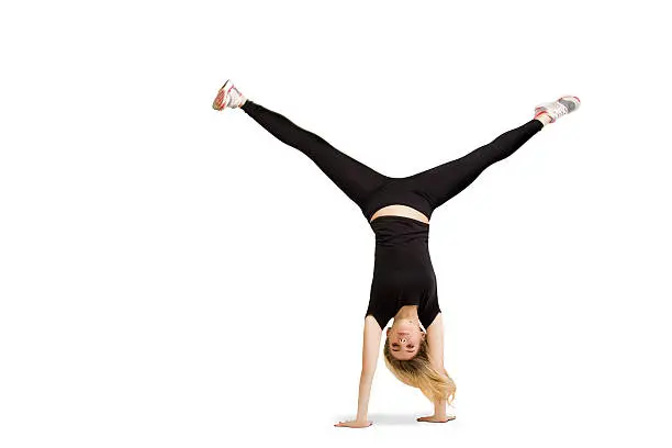 Caucasian woman does cartwheel gymnastics. Fitness girl in handstand isolated at white background. Gymnastics, yoga, fitness pose. Handstand and cartwheel in black clothes isolated at white