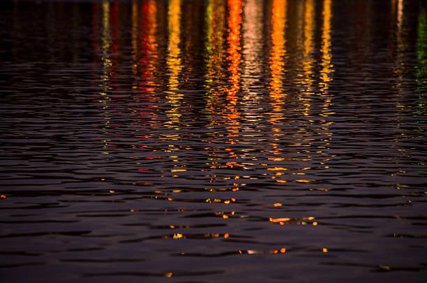 This photograph was taken of colorful lights of city infrastructures that were reflected in water at night.