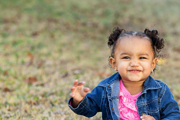 счастливая маленькая девочка - family grass toddler african descent стоковые фото и изобра�жения