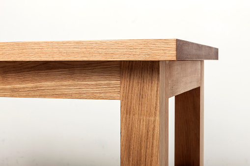 A natural wood(oak) table(desk) corner close up with white background.