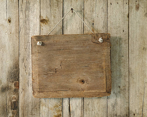 istock Old weathered wood signboard hanging from an old nail. 513878538