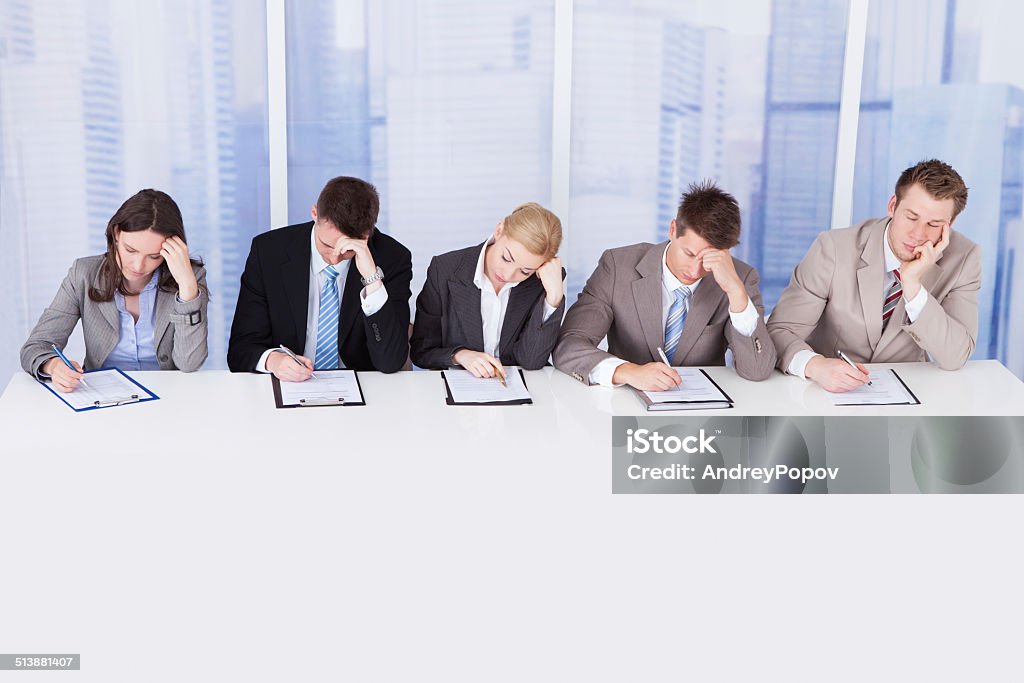 Tired Corporate Personnel Officers At Table Group of tired corporate personnel officers at table in office Adult Stock Photo