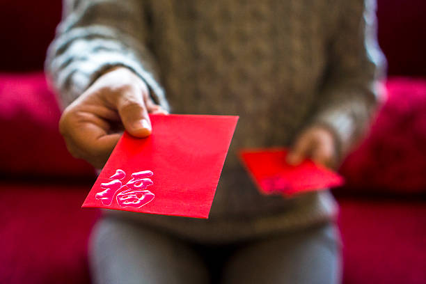 geben rot umschlag von geld für die feiertage - hongbao stock-fotos und bilder