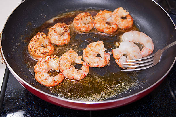 garnelen auf einer pfanne. prozess der küche - pan frying pan fried saucepan stock-fotos und bilder