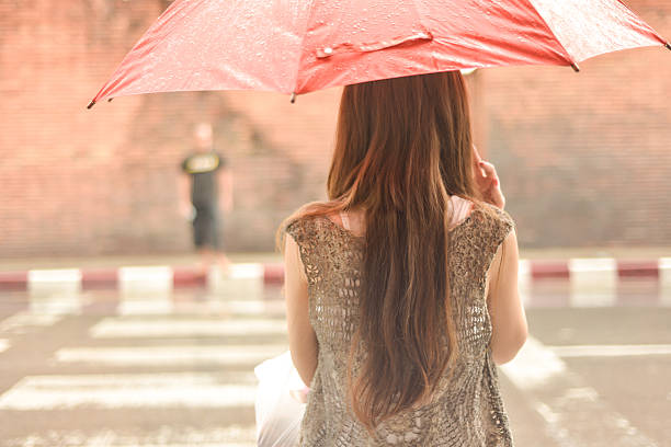 kobieta czeka na krzyż ulicy z parasol w deszczu - parasol umbrella asian ethnicity asian culture zdjęcia i obrazy z banku zdjęć