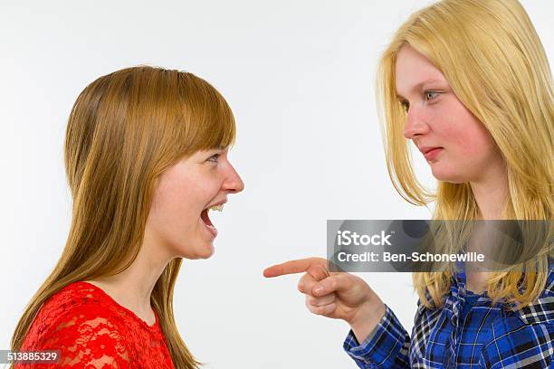 Blonde Girl Pointing At Redhead Girlfriend Stock Photo - Download Image Now - 18-19 Years, Adolescence, Aiming