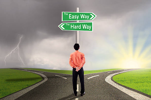 Businessman choose easy or hard way Businessman choose easy or hard way with stormy clouds background no brainer sign stock pictures, royalty-free photos & images