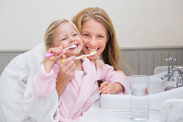 glückliche mutter und tochter zähne putzen - child brushing human teeth brushing teeth stock-fotos und bilder