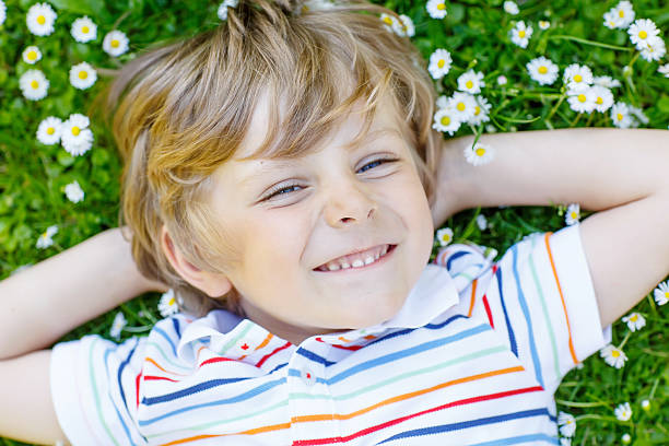 istock Happy kid boy laying on green grass in summer 513888850