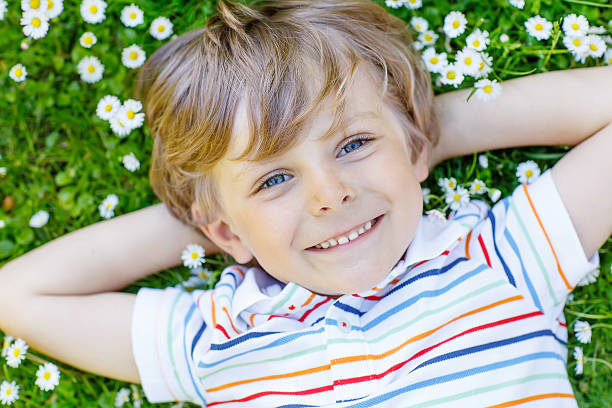 istock Happy kid boy laying on green grass in summer 513889122