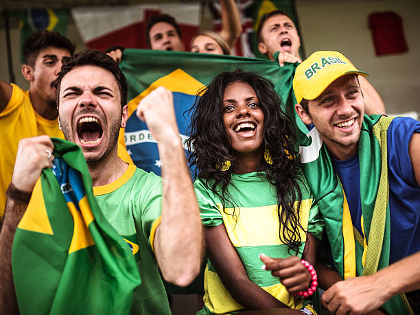 Brazilian supporters cheering at stadium Brazilian sports fans at a stadium. hand fan photos stock pictures, royalty-free photos & images